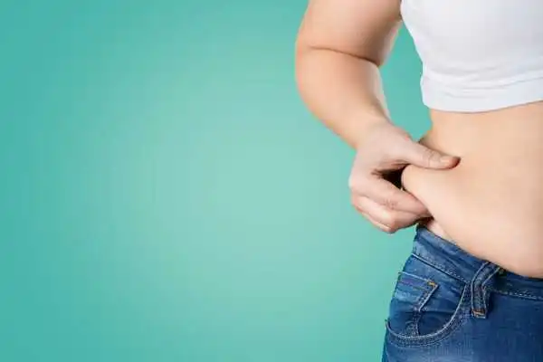 Image of woman pinching her love handles to show weight gain Berkhamsted